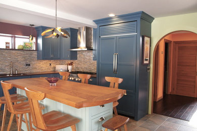 Large transitional u-shaped slate floor and beige floor enclosed kitchen photo in Burlington with shaker cabinets, blue cabinets, an island, a double-bowl sink, granite countertops, multicolored backsplash, matchstick tile backsplash, paneled appliances and brown countertops