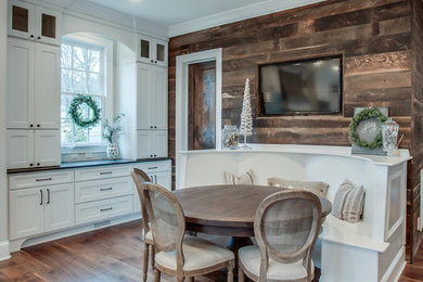 Inspiration for a large traditional u-shaped eat-in kitchen in Wichita with a farmhouse sink, recessed-panel cabinets, white cabinets, marble benchtops, beige splashback, subway tile splashback, stainless steel appliances, medium hardwood floors and with island.