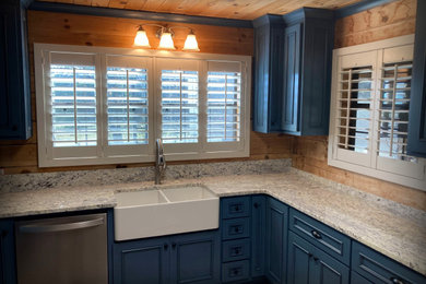 Example of a mid-sized mountain style u-shaped laminate floor, gray floor and wood ceiling kitchen design in Other with a farmhouse sink, beaded inset cabinets, blue cabinets, granite countertops, stainless steel appliances, an island and multicolored countertops