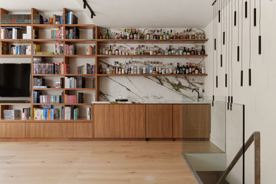 Large minimalist loft-style light wood floor and beige floor living room library photo in New York with white walls, a standard fireplace, a stone fireplace and a media wall