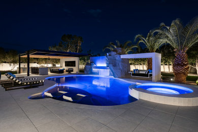Large trendy backyard stone and custom-shaped hot tub photo in Phoenix