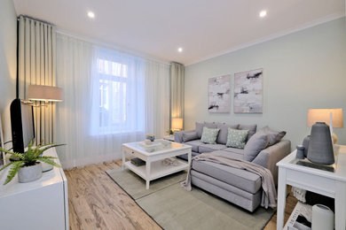 Foto de salón cerrado y gris y blanco pequeño con paredes verdes, suelo laminado, televisor independiente y cortinas