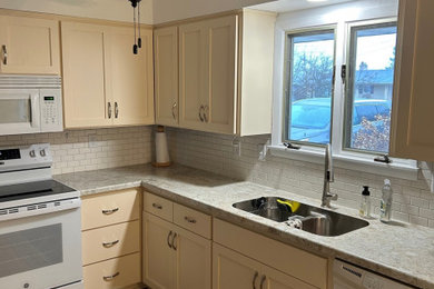 Mid-sized minimalist u-shaped enclosed kitchen photo in Other with laminate countertops