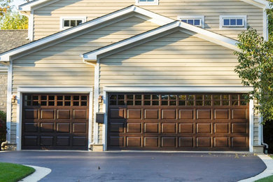 Garage - large traditional attached three-car garage idea in New York