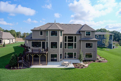 Large traditional brown three-story mixed siding house exterior idea in Milwaukee with a mixed material roof and a hip roof