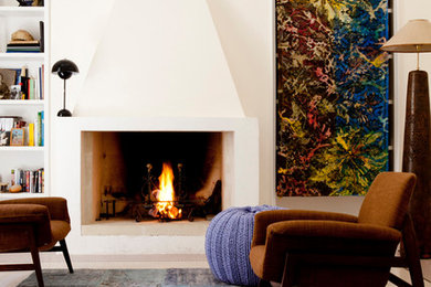 Example of a tuscan open concept living room design in Other with beige walls, a standard fireplace, a plaster fireplace and no tv
