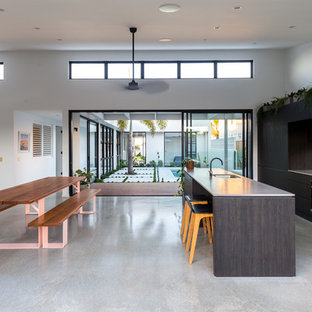 Idee per una cucina contemporanea con lavello sottopiano, ante lisce, ante in legno bruno, paraspruzzi a finestra, pavimento in cemento, pavimento grigio e top bianco