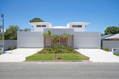 Inspiration for a beach style two-storey white exterior in Sunshine Coast with a metal roof and a white roof.