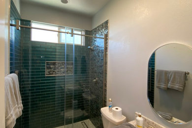 Example of a minimalist 3/4 blue tile ceramic tile, gray floor and single-sink bathroom design in Los Angeles with brown cabinets, a one-piece toilet, an undermount sink, quartzite countertops, a niche and a built-in vanity