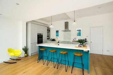 Design ideas for a large contemporary eat-in kitchen in London with an undermount sink, shaker cabinets, grey cabinets, quartzite benchtops, green splashback, ceramic splashback, light hardwood floors, with island, beige floor and white benchtop.