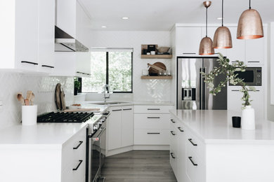Inspiration for a small modern l-shaped laminate floor, gray floor and tray ceiling eat-in kitchen remodel in Vancouver with an undermount sink, flat-panel cabinets, white cabinets, quartz countertops, white backsplash, ceramic backsplash, stainless steel appliances, an island and white countertops