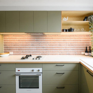This is an example of a small scandinavian l-shaped separate kitchen in Melbourne with a double-bowl sink, flat-panel cabinets, green cabinets, laminate benchtops, multi-coloured splashback, ceramic splashback, white appliances, ceramic floors, beige floor and white benchtop.