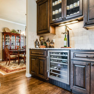 デンバーの小さいラスティックスタイルのおしゃれなウェットバー (レイズドパネル扉のキャビネット、濃色木目調キャビネット、大理石カウンター、ベージュキッチンパネル、テラコッタタイルのキッチンパネル、無垢フローリング) の写真