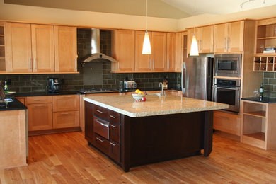 This is an example of a mid-sized modern u-shaped eat-in kitchen in Seattle with a drop-in sink, flat-panel cabinets, light wood cabinets, wood benchtops, black splashback, matchstick tile splashback, stainless steel appliances, light hardwood floors and with island.