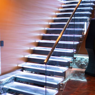 Glass private bar and glass stair treads inside a man cave in Michigan