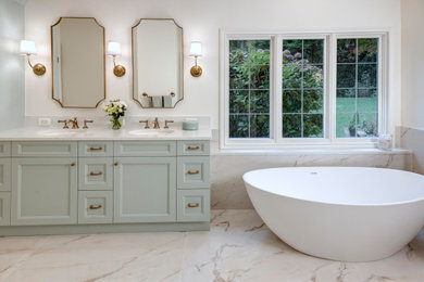 This is an example of a medium sized bathroom in Seattle with green cabinets, a freestanding bath, white tiles, porcelain tiles, white walls, porcelain flooring, a submerged sink, engineered stone worktops, white floors, a hinged door, white worktops, double sinks and a built in vanity unit.
