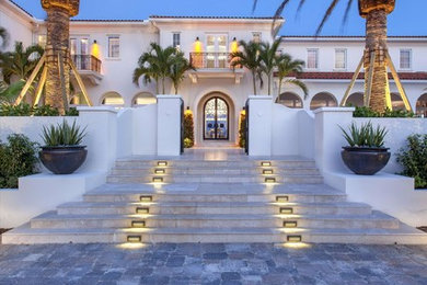 Huge mediterranean white two-story concrete house exterior idea in Miami with a tile roof