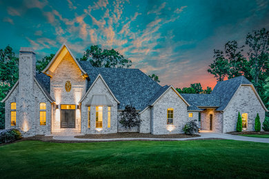 Example of a large minimalist gray three-story brick house exterior design in Other with a hip roof and a shingle roof