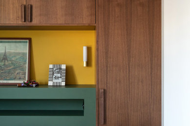 Idée de décoration pour une chambre parentale minimaliste de taille moyenne avec un mur vert, parquet clair et dressing.