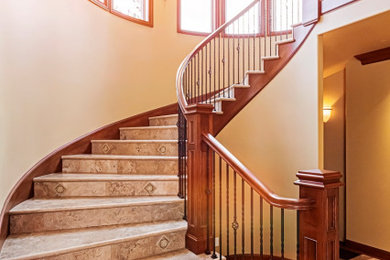 Large eclectic marble curved wood railing staircase photo in Chicago with marble risers