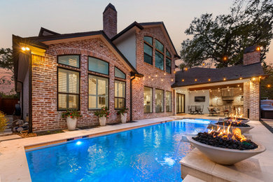 Medium sized contemporary back rectangular swimming pool in Houston with natural stone paving.