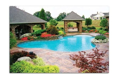 Backyard stone and custom-shaped pool photo in Other