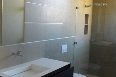 Alcove shower - large beige tile alcove shower idea in Phoenix with a drop-in sink, flat-panel cabinets, dark wood cabinets, a one-piece toilet and beige walls