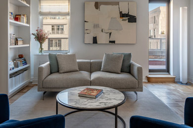 Example of a small minimalist light wood floor and beige floor living room design in New York with white walls, a standard fireplace and a stone fireplace