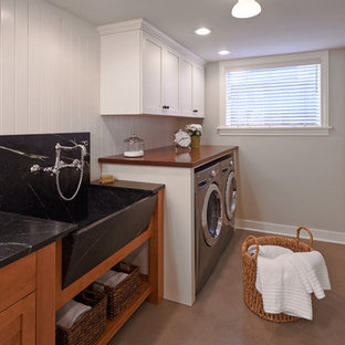 シアトルのモダンスタイルのおしゃれな家事室 (エプロンフロントシンク、木材カウンター、白い壁、左右配置の洗濯機・乾燥機) の写真