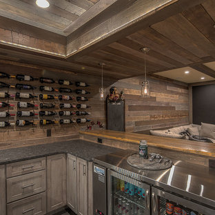 Photo of a large rustic fully buried basement in Other with brown walls, carpet, a hanging fireplace and a tiled fireplace surround.