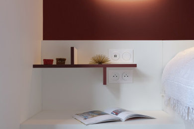 Réalisation d'une chambre parentale design de taille moyenne avec un mur rouge et parquet clair.