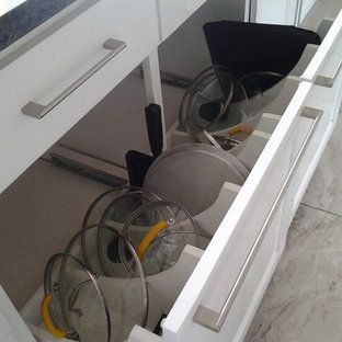 Große Moderne Küche in U-Form mit Vorratsschrank, Unterbauwaschbecken, Schrankfronten im Shaker-Stil, weißen Schränken, Granit-Arbeitsplatte, Küchenrückwand in Grau, Rückwand aus Glasfliesen, Küchengeräten aus Edelstahl, Porzellan-Bodenfliesen und zwei Kücheninseln in Sonstige