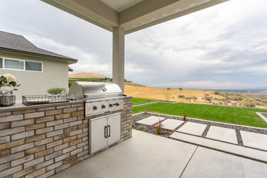 Example of a transitional backyard concrete patio kitchen design in Seattle with a roof extension