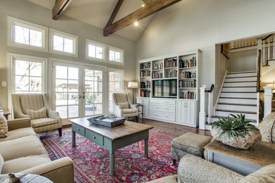 Large transitional open concept dark wood floor living room library photo in Dallas with a media wall, gray walls and no fireplace
