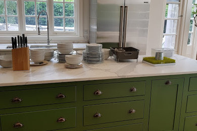 This is an example of a large classic kitchen in London with shaker cabinets and an island.