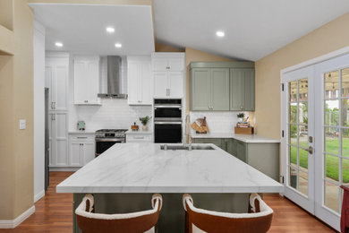 Open concept kitchen - mid-sized country laminate floor, brown floor and vaulted ceiling open concept kitchen idea in Los Angeles with an undermount sink, shaker cabinets, white cabinets, quartz countertops, white backsplash, subway tile backsplash, stainless steel appliances, an island and white countertops