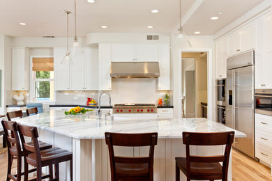 Elegant light wood floor kitchen photo in San Diego with white cabinets, soapstone countertops, white backsplash and stainless steel appliances