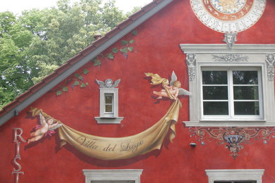 Großes, Zweistöckiges Klassisches Haus mit Betonfassade, roter Fassadenfarbe und Satteldach in Sonstige