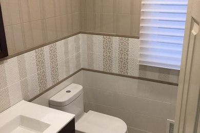 Bathroom - modern 3/4 porcelain tile and beige floor bathroom idea in New York with furniture-like cabinets, dark wood cabinets, a one-piece toilet and an integrated sink