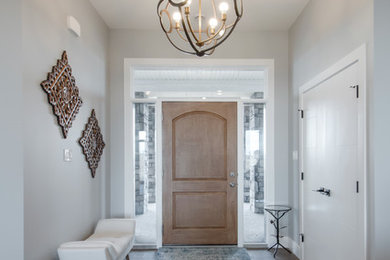 Mid-sized transitional medium tone wood floor entryway photo in Calgary with gray walls and a medium wood front door