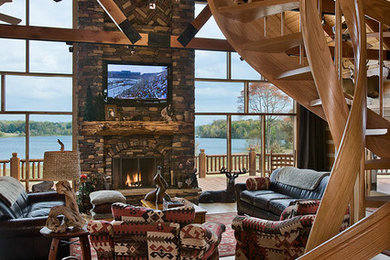 Large mountain style formal and open concept light wood floor living room photo in Other with a standard fireplace, a stone fireplace, a wall-mounted tv and brown walls