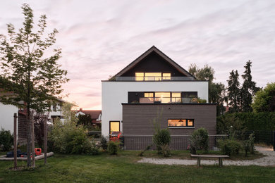Mittelgroßes, Dreistöckiges Modernes Wohnung mit Mix-Fassade, weißer Fassadenfarbe, Satteldach, Ziegeldach, grauem Dach und Verschalung in München