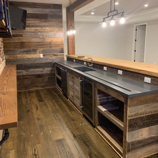 デトロイトの大きいカントリー風おしゃれな着席型バー (アンダーカウンターシンク、白いキャビネット、木材カウンター、マルチカラーのキッチンパネル、レンガのキッチンパネル、無垢フローリング、茶色い床、ベージュのキッチンカウンター) の写真