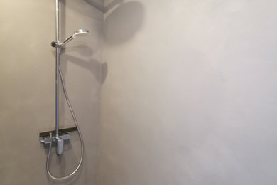Kleines Modernes Duschbad mit hellen Holzschränken, offener Dusche, weißer Wandfarbe, Waschtisch aus Holz, grauem Boden, Einzelwaschbecken und eingebautem Waschtisch in Köln