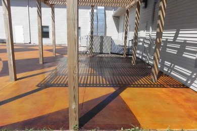 Inspiration for a large contemporary backyard concrete patio remodel in Other with a pergola