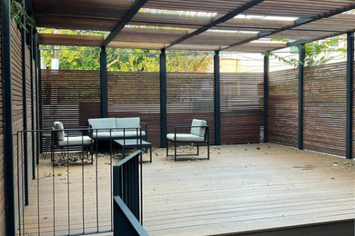 Deck - large side yard second story wood railing and privacy deck idea in New York with a pergola