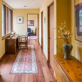 Idee per un ingresso o corridoio stile americano di medie dimensioni con pareti gialle, pavimento in legno massello medio e pavimento marrone