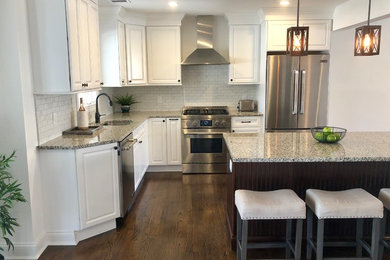 Inspiration for a mid-sized timeless dark wood floor kitchen remodel in New York with a single-bowl sink, granite countertops, yellow backsplash, ceramic backsplash, stainless steel appliances, an island and multicolored countertops