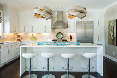 Example of a mid-sized trendy kitchen design in Minneapolis with shaker cabinets, white cabinets, beige backsplash, subway tile backsplash, stainless steel appliances and an island