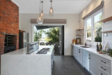 Inspiration for a transitional galley kitchen in Geelong with a double-bowl sink, recessed-panel cabinets, grey cabinets, white splashback, stainless steel appliances, with island, grey floor and white benchtop.